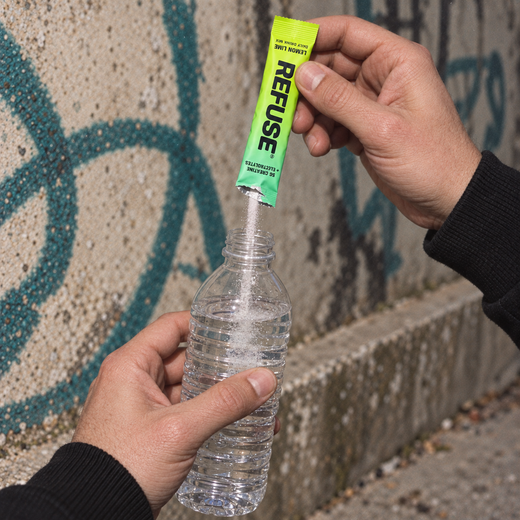 A REFUSE lemon lime stick pouring powder into a bottle of water